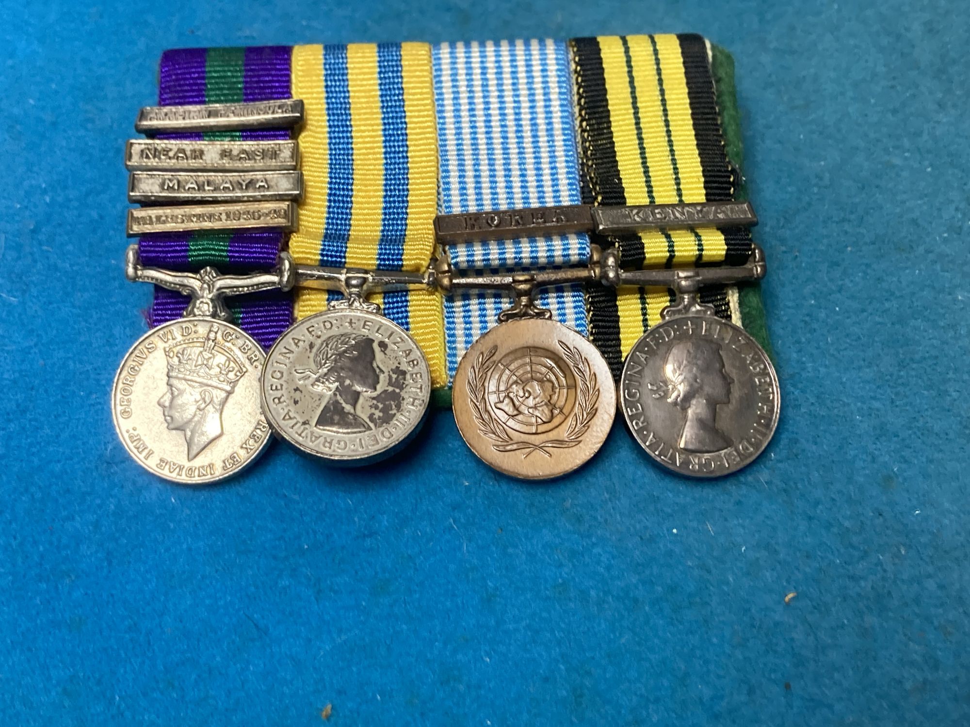 A group of Special Air Service SAS embroidered insignia, a belt and other military items, includes a Malayan Scouts insignia and a group of unnamed miniatures
